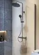 Duschsystem von Ideal Standard mit einem Wandpaneel, einer Handbrause und einer Kopfbrause, montiert in einem modernen Badezimmer mit grauen Fliesen und heller Wand.